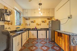 a kitchen with wooden cabinets and a stainless steel refrigerator at The Yellow House By Leela in Patnem +29 photos