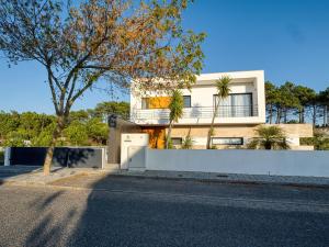 a house with a white fence and a tree at Maresia Villa Mar in Nazaré