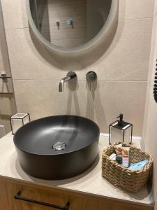 a black sink in a bathroom with a mirror at Philoxenia by nature in Karkaloú +35 photos