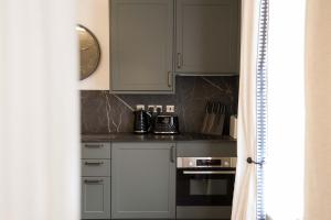 a kitchen with white cabinets and a stove top oven at Lovely Studio Flat on Bath Road - Flat 10 in Bristol
