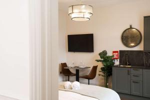 a room with a table and a clock on the wall at Lovely Studio Flat on Bath Road - Flat 10 in Bristol
