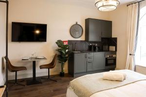 a bedroom with a kitchen with a bed and a table at Lovely Studio Flat on Bath Road - Flat 10 in Bristol