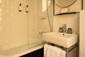 a white bathroom with a sink and a shower at 9Hotel Bastille-Lyon in Paris +32 photos