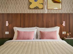 a bed with pink and white pillows in a bedroom at Numa Florence Rodo in Florence