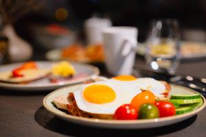 a plate of food with eggs and vegetables on a table at Frichs Hotel Hamar in Hamar