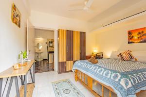 a bedroom with a large bed and a desk at The Yellow House By Leela in Patnem