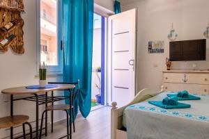a small room with a bed and a table at Affittacamere LiKele in Castelsardo