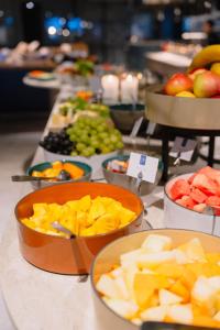 a buffet with bowls of fruit on a table at Frichs Hotel Hamar in Hamar