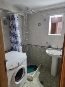 a bathroom with a washing machine and a sink at Jim's House in Káspakas +8 photos