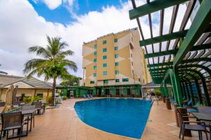 a swimming pool in front of a building at Alisa Hotel North Ridge in Accra