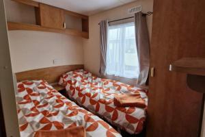 two beds in a small room with a window at Palm Court - 3 Bed Heated Pool Parking Nr Beach in Par +22 photos