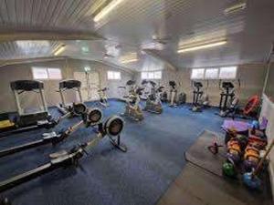 a gym with many exercise equipment in a room at Palm Court - 3 Bed Heated Pool Parking Nr Beach in Par