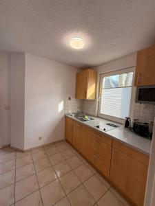 a kitchen with wooden cabinets and a sink and a window at Wittower Heide 40-2 in Glowe