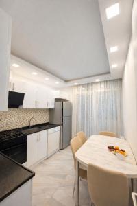 a kitchen with a white table and chairs in a room at dupleqs batumi daRia in Angisa