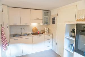 a kitchen with white cabinets and a sink at La Casina Del Campese in Campese