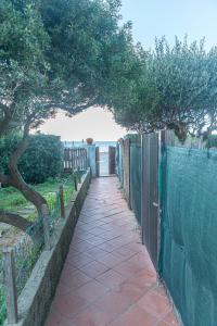 a walkway with a fence next to the ocean at La Casina Del Campese in Campese