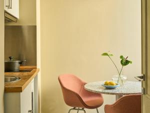 a kitchen with a table with chairs and a bowl of fruit at Numa Florence Rodo in Florence