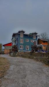 a large blue house sitting on top of a dirt road at Hotel castle rock in Pahalgām