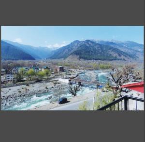 a view of a river with mountains in the background at Hotel castle rock in Pahalgām