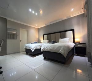 a hotel room with two beds and two lamps at Viking Guest House in Mahikeng