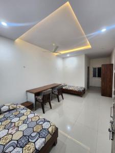 a room with a bed and a table and chairs at Omisha Stay & Pavilion in Sehore