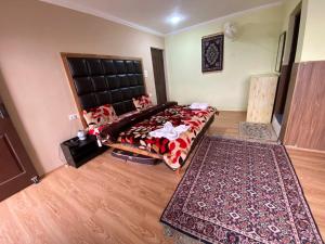 a bedroom with a large bed and a rug at Hotel castle rock in Pahalgām +5 photos
