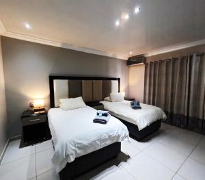 a hotel room with two beds and a window at Viking Guest House in Mahikeng