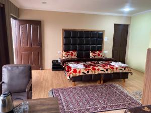 a bedroom with a bed and a chair and a table at Hotel castle rock in Pahalgām