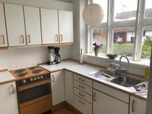 a kitchen with white cabinets and a sink at Vejlø Skole - Degnegaarden in Næstved
