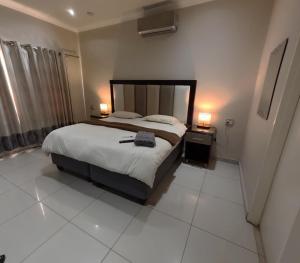 a bedroom with a large bed and two lamps at Viking Guest House in Mahikeng