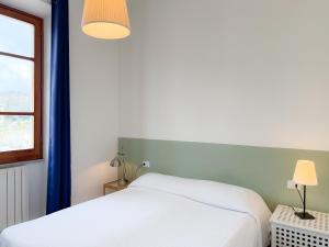 a bedroom with two white beds and a window at Ponticello Mare - HelloElba in Portoferraio