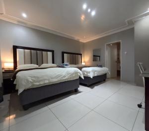 a large bedroom with two beds and a desk at Viking Guest House in Mahikeng +3 photos
