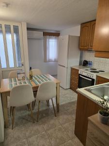 a kitchen with a table and chairs and a refrigerator at Jim's House in Káspakas