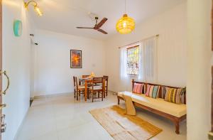 a living room with a couch and a table at The Yellow House By Leela in Patnem
