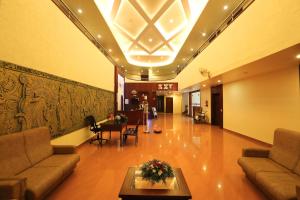 a lobby with couches and a table and a piano at Hotel Indraprastha varkala in Varkala
