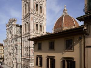 a building with a clock tower next to a church at Numa Florence Rodo in Florence