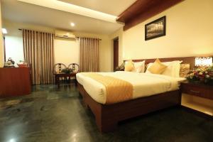 a bedroom with a large bed in a hotel room at Hotel Indraprastha varkala in Varkala