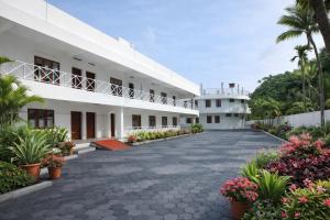 a courtyard of a building with flowers and plants at Hotel Indraprastha varkala in Varkala