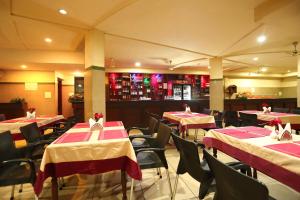 a restaurant with red and white tables and chairs at Hotel Indraprastha varkala in Varkala +9 photos
