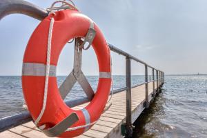 ein roter Rettungsring auf einem Dock in der Nähe des Wassers in der Unterkunft Immerschön in Schilksee