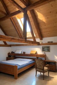 a bedroom with a bed and a chair in a attic at Jílová tvrz in Rožmberk nad Vltavou