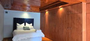 a bedroom with a bed and a large wooden cabinet at Relax Guest House in Goodwood