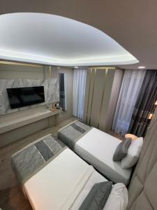 a bedroom with two beds and a flat screen tv at Elysia Plus Hotel in Istanbul