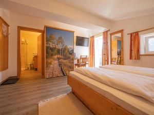 a bedroom with a bed and a painting of a train at Alpenhof Apartments in Mittersill