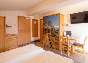 a bedroom with a large sliding door with a painting of a view at Alpenhof Apartments in Mittersill