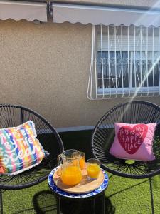 two chairs with two glasses of orange juice and a pillow at Apartamento en Lorca Murcia in Lorca