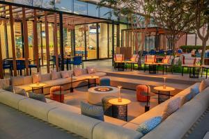a restaurant with tables and chairs in a building at Aloft by Marriott Me’aisam, Dubai in Dubai