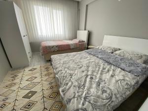 a bedroom with two beds and a rug at Kuğu Apart Pansiyon in Sinop
