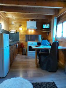 a kitchen with a refrigerator and a table at Chalet romantique avec piscine in Monthion