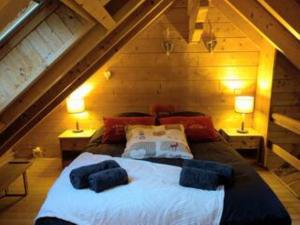 a bedroom with a large bed in a attic at Chalet romantique avec piscine in Monthion